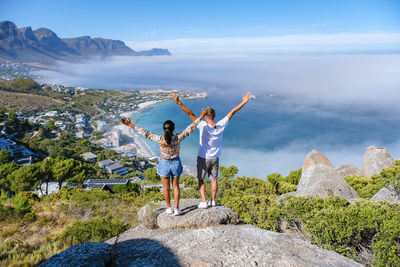 Rear view of couple standing against sea