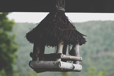 Close-up of birdhouse on roof against sky