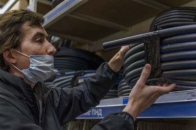 Man choosing water pipe standing near the showcase in retail store