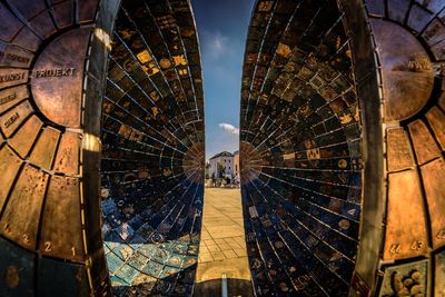 Splitted earth sculpture in city against sky