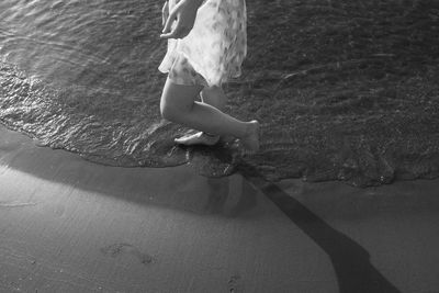 Low section of woman walking in swimming pool