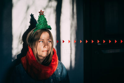 Close-up woman wearing christmas decoration in darkroom