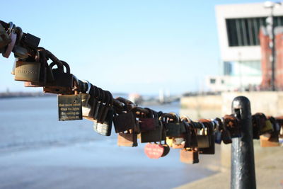 Close-up of padlocks on metal against sky