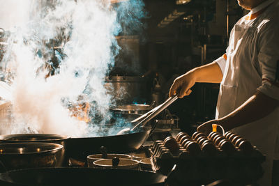 Midsection of person preparing food in kitchen