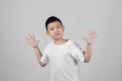 Full length of boy standing against white background