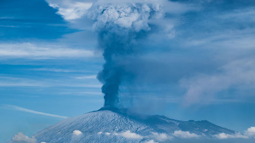 Smoke emitting from volcanic mountain against sky