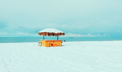 Lifeguard hut on beach against sky