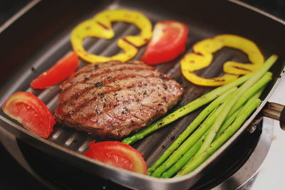 Close-up of grilled meat and vegetables in cooking pan