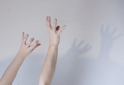 Close-up of woman hand against white wall