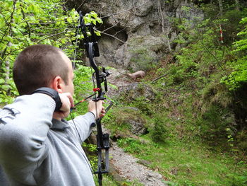 Close-up of man hunting deer in forest