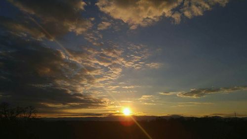 Silhouette of landscape against cloudy sky