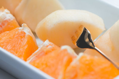 Close-up of fresh orange and muskmelon in plate