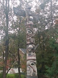 Low angle view of text on tree trunk in forest