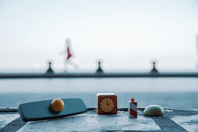 Close-up of clock on table against sea