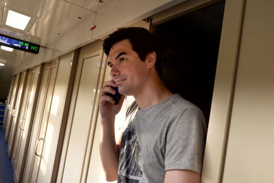 Young man looking through window