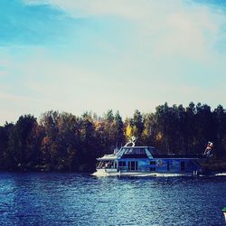 Boat in lake against cloudy sky