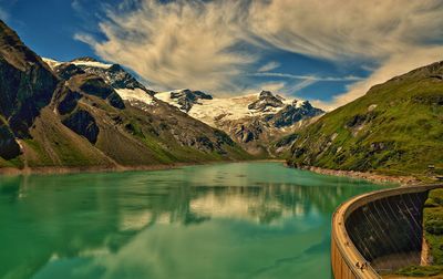 Scenic view of lake by mountains against sky