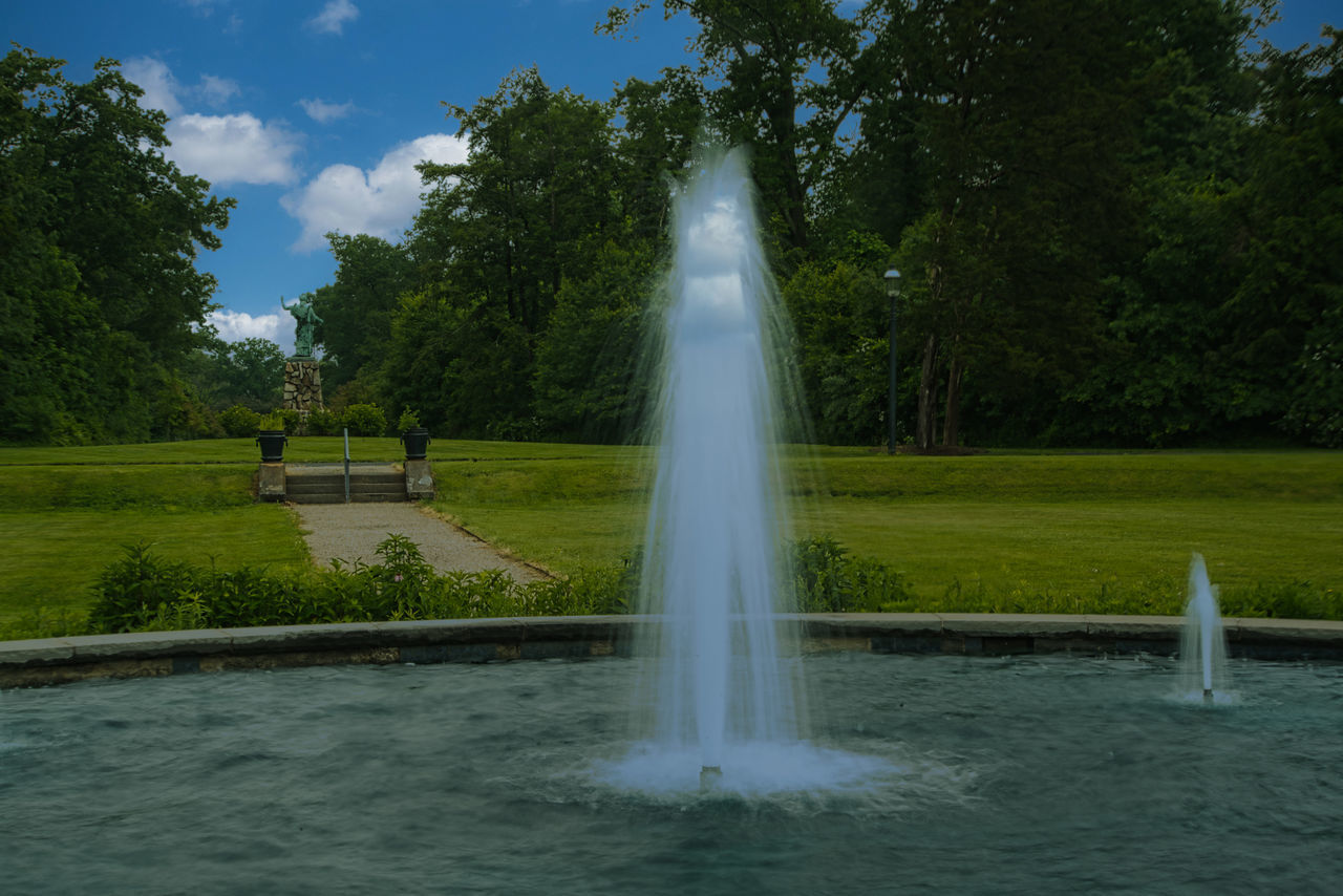 water, plant, tree, fountain, water feature, nature, spraying, motion, reflecting pool, sky, park, green, day, beauty in nature, architecture, splashing, outdoors, cloud, reflection, grass, park - man made space, no people, scenics - nature, long exposure, environment, travel destinations, lake, tourism, body of water, travel, flowing water