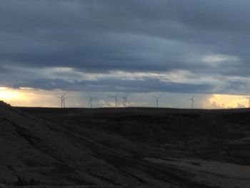 Scenic view of field against cloudy sky