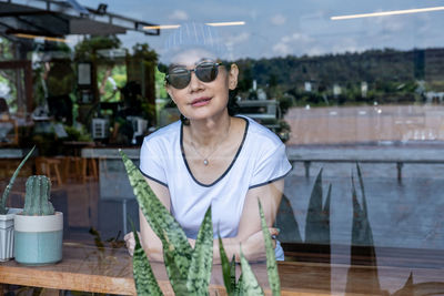 Young woman wearing sunglasses on table