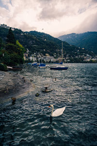 Scenic view of sea by mountain against sky