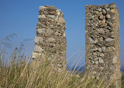Low angle view of rocks against clear blue sky