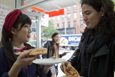 Young woman holding ice cream in restaurant