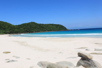 Scenic view of beach against clear blue sky