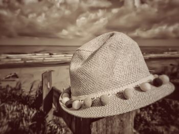 Close-up of hat on beach against sky
