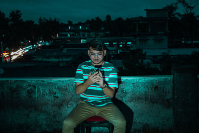 Portrait of teenage boy sitting outdoors