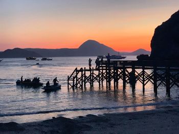 Silhouette people on sea against sky during sunset at dawn sunrise padar island komodo 