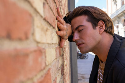 Portrait of young woman against wall