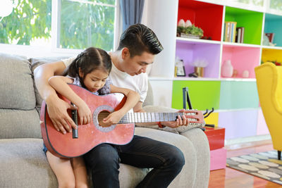 Mother and daughter playing on sofa