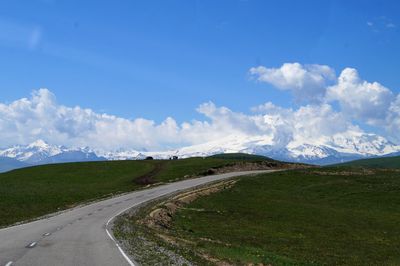 Road by landscape against sky