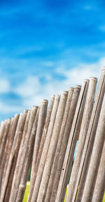 Close-up of wooden fence against blue sky