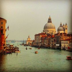 Boats in river with buildings in background