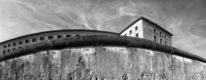 Low angle view of built structure against cloudy sky