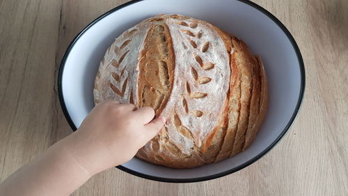 Directly above shot of person holding bread on table