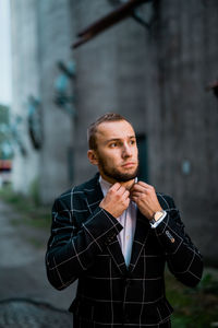 Portrait of young man looking away in city