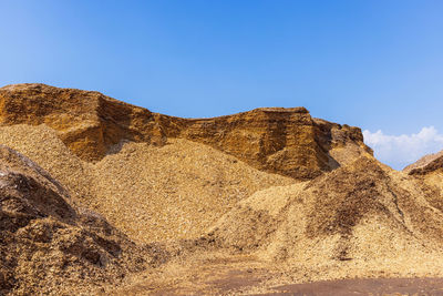 Low angle view of rock formations against clear blue sky