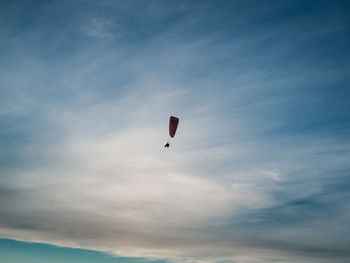 Low angle view of person paragliding against sky