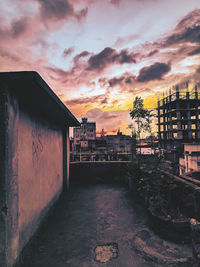 Buildings in town against sky during sunset