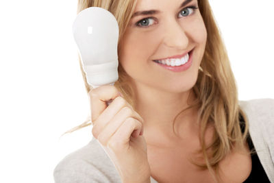 Woman holding equipment during pregnancy test against white background