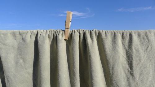 Close-up of fabric on clothesline against sky