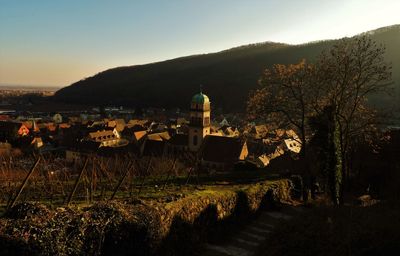 Town by mountains against clear sky during sunset