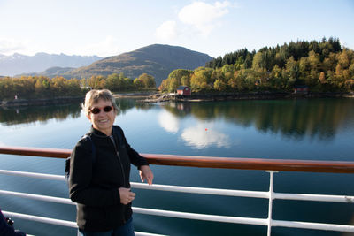 Rear view of woman standing by lake