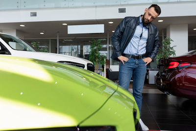 Side view of man standing in car