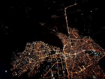 Low angle view of illuminated city against sky at night