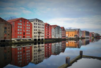 Buildings in city against cloudy sky