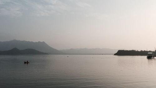 Scenic view of calm sea against mountain range